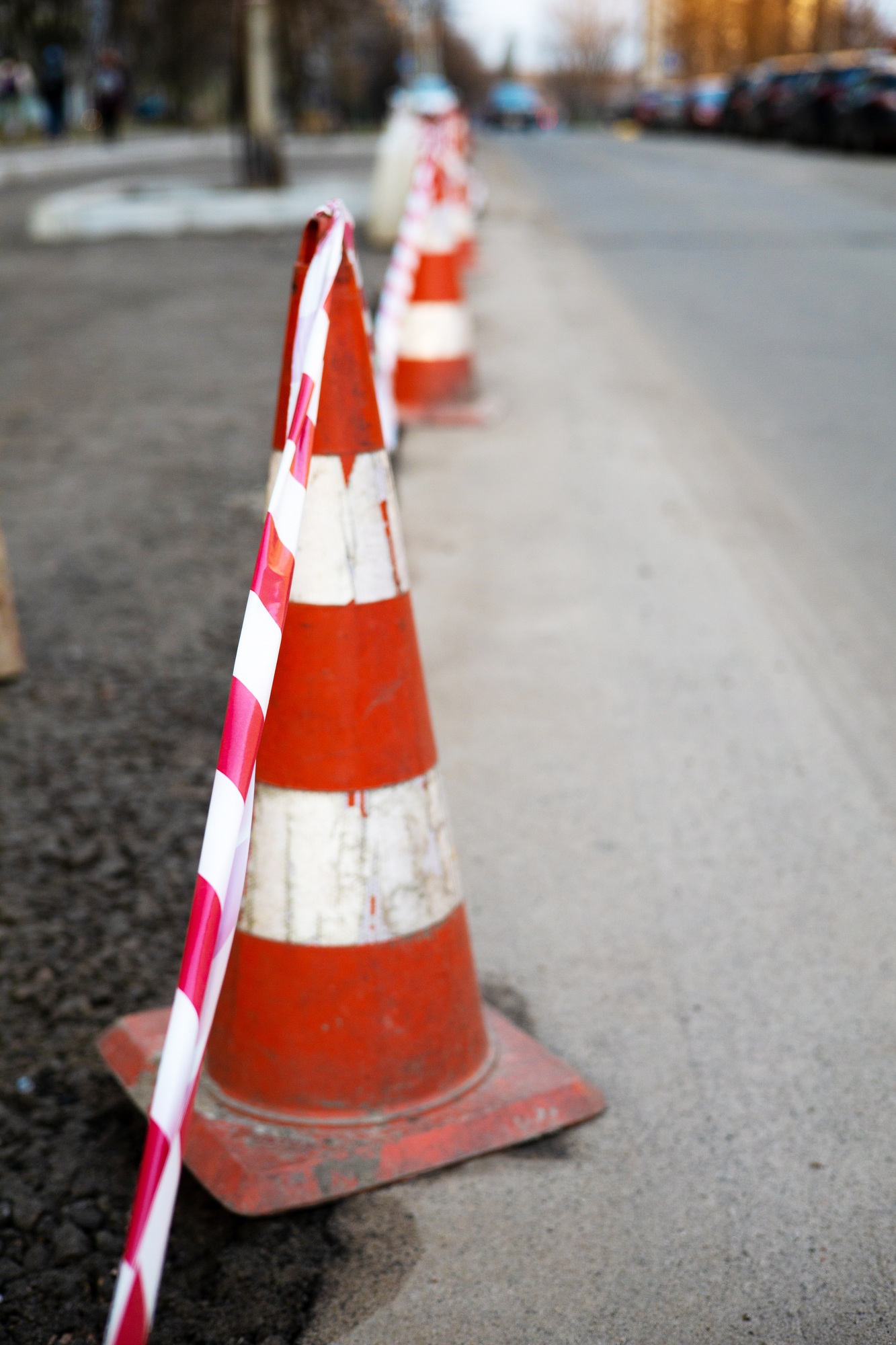 Under construction board sign on the closed road with arrow sign and traffic cone. Caution symbol un